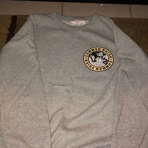 Grey sweater. Says “common noise • common voice”